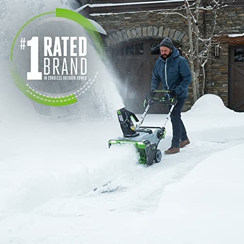 Man using a snow blower to clear a snow-covered driveway